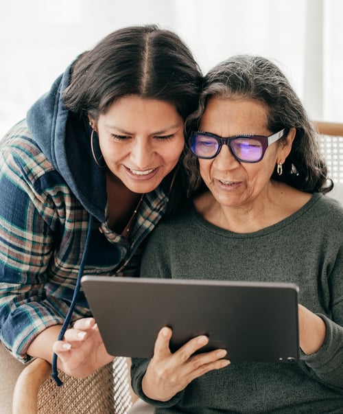 Mature woman and daughter looking at tablet